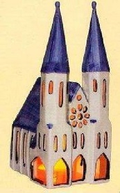 Das Bild zeigt ein detailreiches Modell eines gotischen Doms. Er ist in wei gehalten, mit dunkelblauen Dchern. Der Dom hat zwei hohe Trme und ein detailliertes Giebeldach. Die Fenster lassen ein warmes, oranges Licht durchscheinen, was auf eine Beleuchtung im Inneren hindeutet. Das Modell wirkt handgefertigt und detailreich, mit einer gewissen rustikalen Anmutung. Der Dom ist aus Porzellan gefertigt und wahrscheinlich ein Souvenir oder ein Sammlerstck. Er strahlt eine gemtliche und friedliche Atmosphre aus, die an religise Architektur und Geborgenheit erinnert. Das Bild ist einfach, aber effektiv in seiner Darstellung des Modells und seiner Details. Es ist wohl auch als Teelichthaus zu nutzen und von hinten zu beleuchten.
